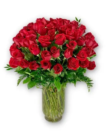 100 red roses arranged in a vase with greenery