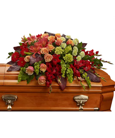 Casket Spray in reds, oranges & greens including roses, lilies & hydrangea