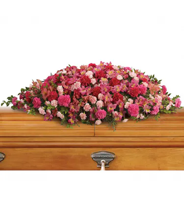 Casket spray includes alstroemeria, carnations and miniature carnations in shades of pink