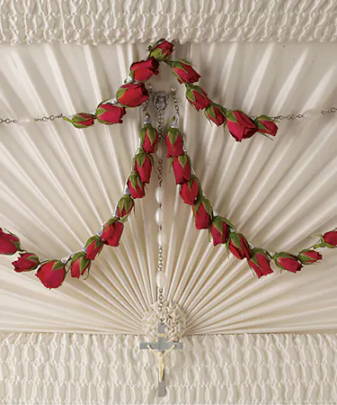 The 50-bead rosary is decorated with red spray roses.