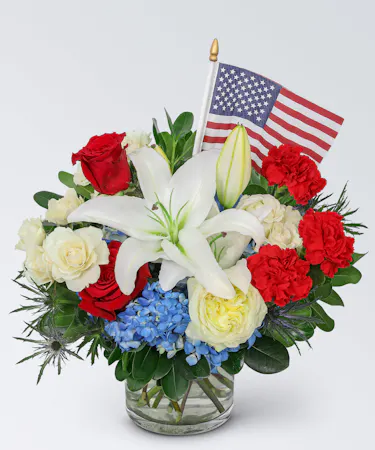 Featuring a vibrant mix of hydrangea, roses, carnations, lilies, and other premium foliage