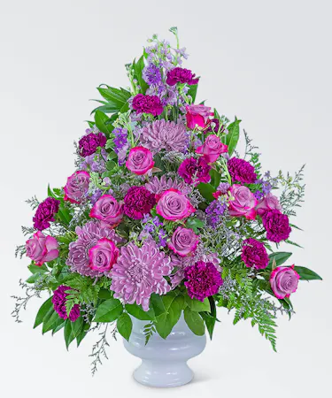 White urn with lavender roses, lavender chrysanthemums, purple daisies