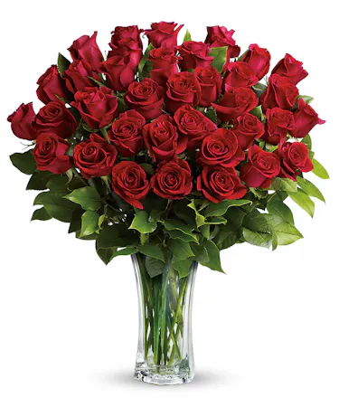 Two dozen roses and greenery in a sparkling clear glass vase