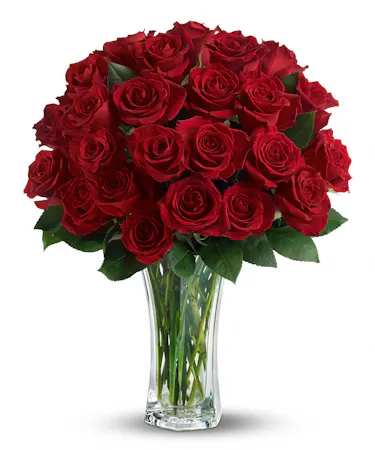Two dozen roses and greenery in a sparkling clear glass vase
