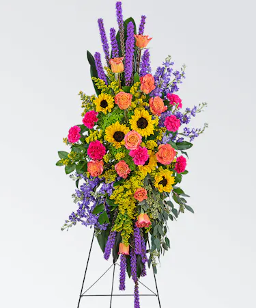 Bright colored easel spray featuring sunflowers and orange roses