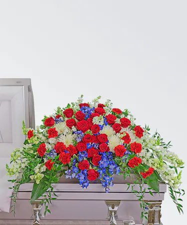 Red, white and blue casket spray with roses, chrysanthemums, carnations and delphinium
