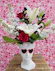This edgy Valentine's gift features a cool sunglass-wearing bust filled with red roses, white lilies, and dark foliage.
