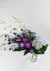 Blue dendrobium orchids paired with blue hydrangea & green hypericum hand-designed in a clear glass vase.