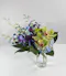 Blue dendrobium orchids paired with blue hydrangea & green hypericum hand-designed in a clear glass vase.