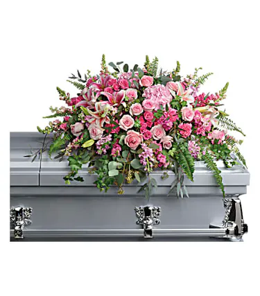 Casket spray in all pink, featuring hydrangea, rosers, lilies, snap dragons and greenery