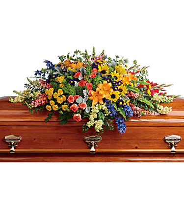 A colorful casket spray featuring sunflowers, hydrangea, roses, lilies and more