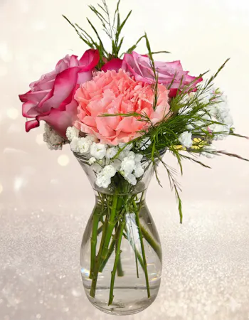 lavender roses, pink carnations and baby's breath in a small vase