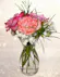 lavender roses, pink carnations and baby's breath in a small vase