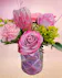 Pink protea, lavender roses, pink carnations in a geometric pink cylinder