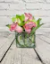 Green hydrangea and cymbidium orchids with lavender roses in a clear glass cube